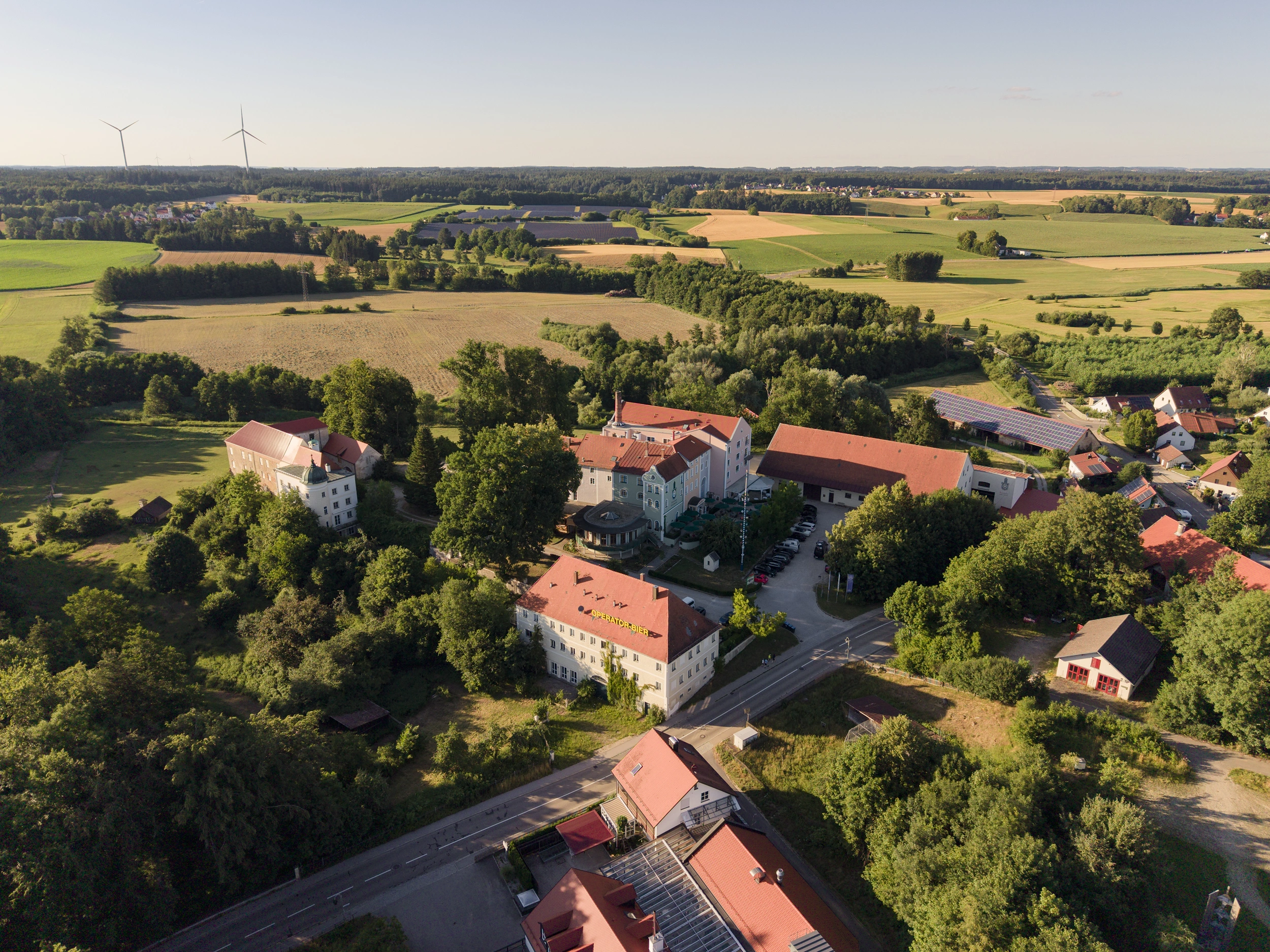 Aerial view of Schlossgut Odelzhausen surrounded by fields and woods