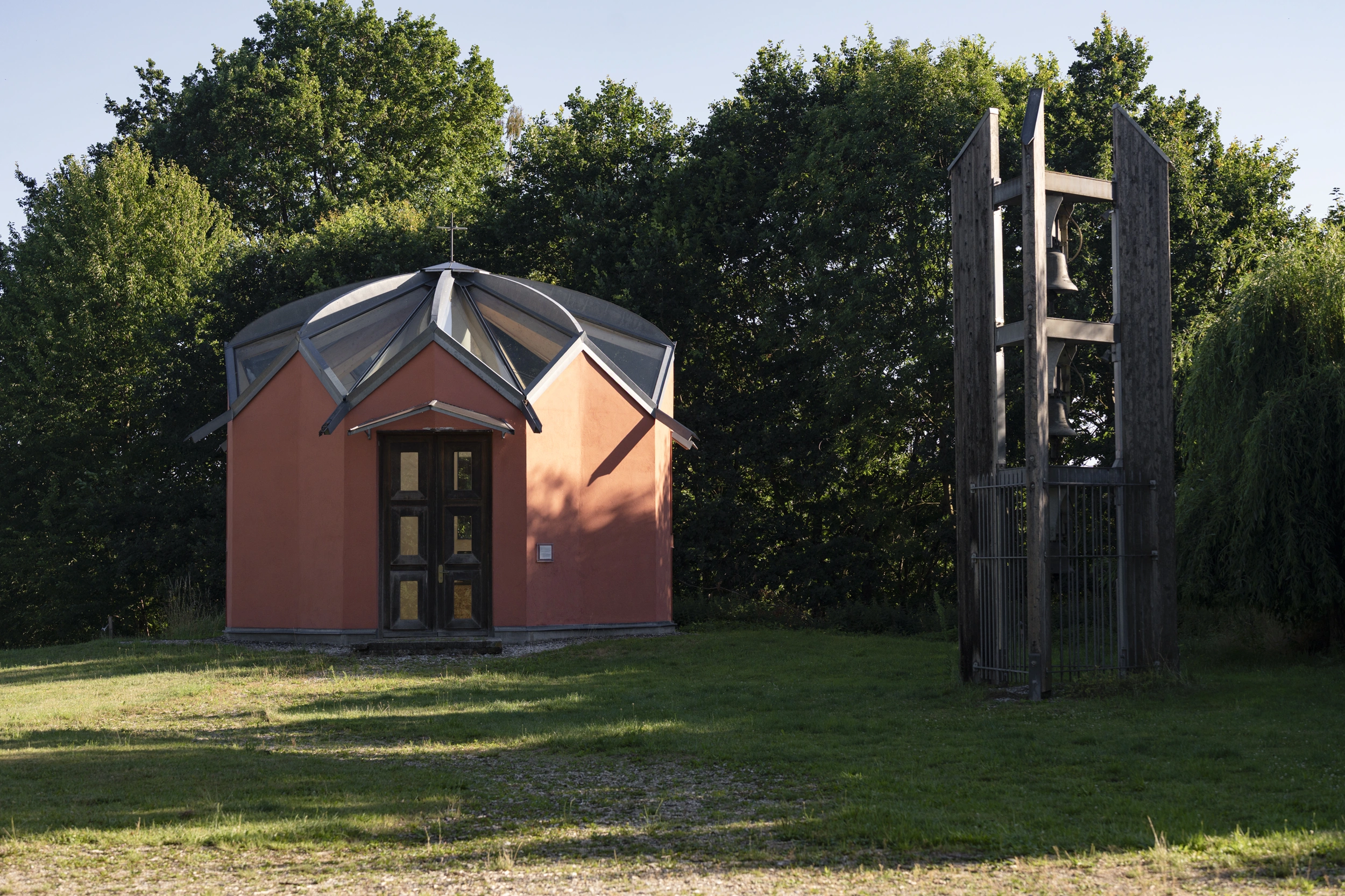 Kapelle mit hölzernem Glockenturm auf einer Wiese