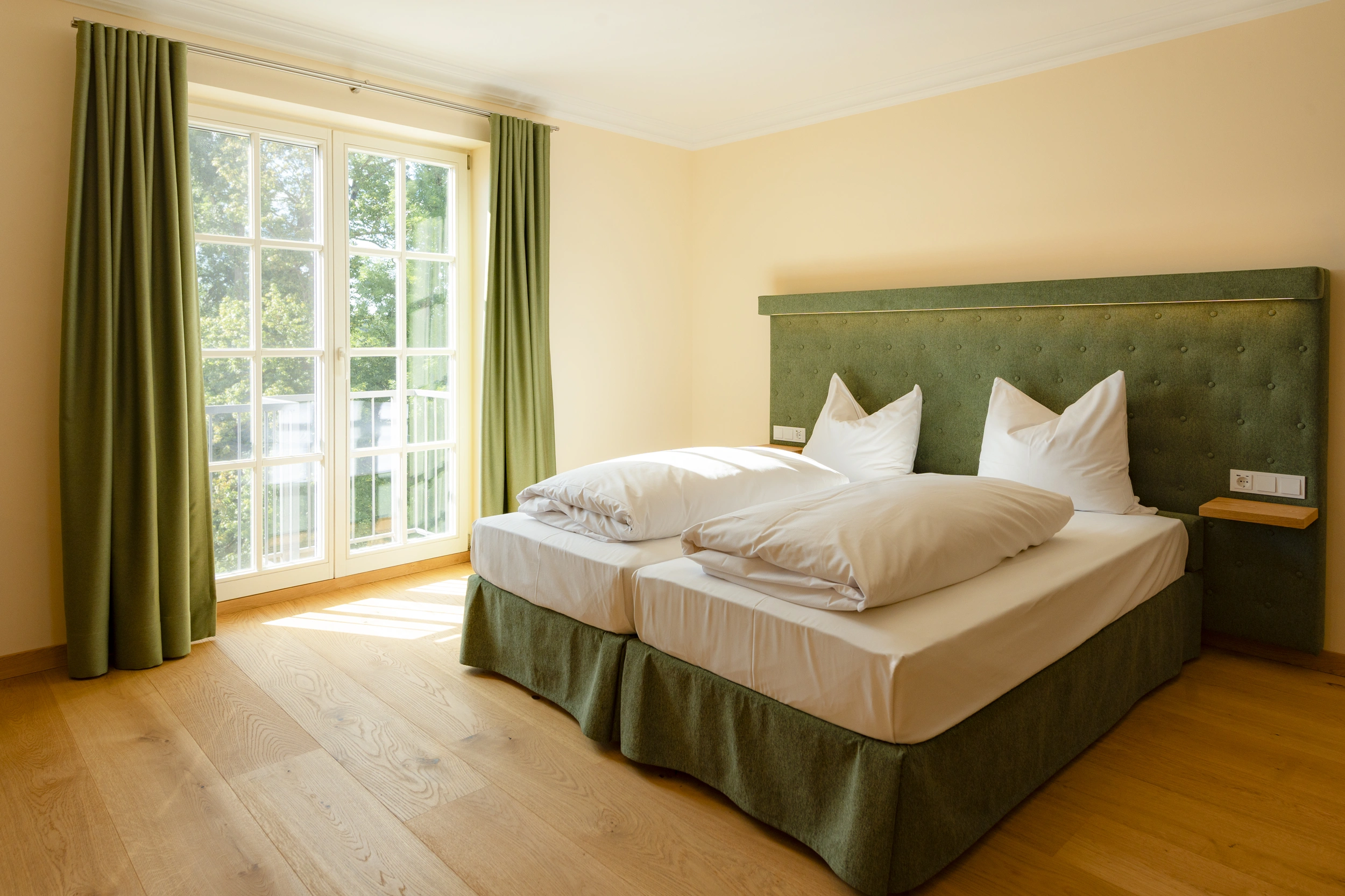 Kamin-Doppelzimmer mit Doppelbett und großer Fensterfront ins Grüne